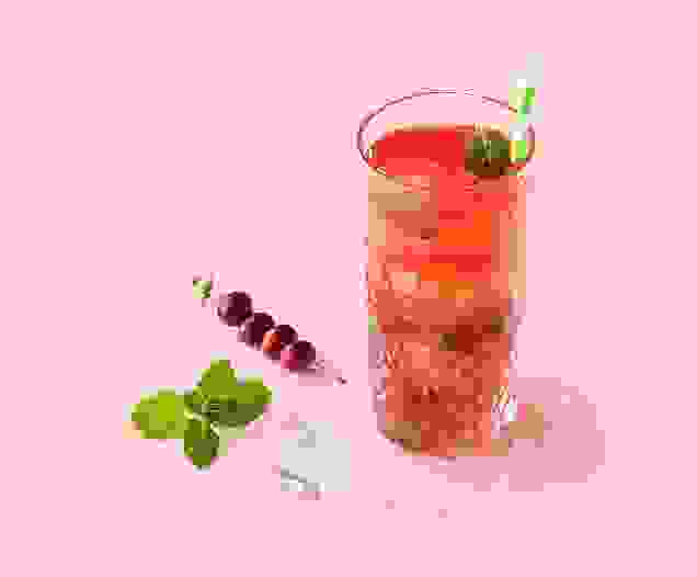 Cocktail Cosmic Cranberry réalisé avec le sirop Pêche ou Grenadine Teisseire, servi dans un verre.